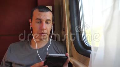 男子听着火车车厢车厢车厢车厢上的音乐旅行。 慢动作视频。 男人的生活方式