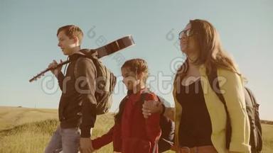 快乐家庭慢动作视频行走在大自然男孩女孩和妈妈在野外徒步旅行的生活方式之旅。 带着