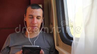 男子听着火车<strong>车厢车厢车厢车厢</strong>上的音乐旅行。 慢动作视频。 有智能手机的男人