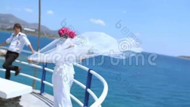 新娘新郎和新娘结婚后在海滩上`面纱随风飘扬
