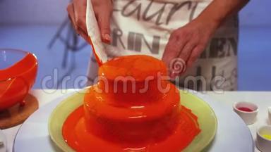 圆形<strong>双层蛋糕</strong>与橙色奶油顶部正在慢慢平滑。