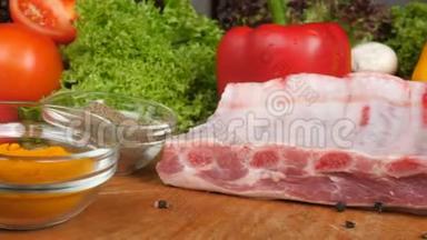 不同种类的肉放在生菜叶子蔬菜的背景上的木板上。 牛肉、鸡肉