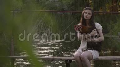穿着白色衣服的女孩正坐在河上，坐在木桥上拥抱公鸡