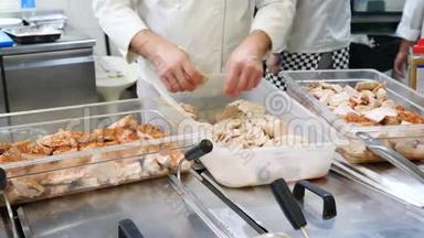 厨师在餐厅的厨房里放了很多切碎的鸡肉或火鸡片，腌制成白色