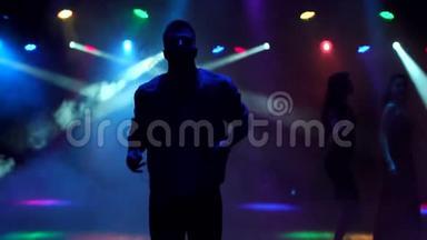 一个现代的年轻人在夜总会的黑暗中跳舞