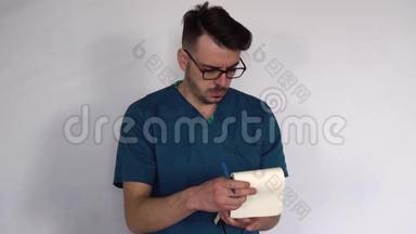 一位戴着眼镜和蓝色实验室外套的年轻医生在克林尼斯特写的笔记本上做笔记。