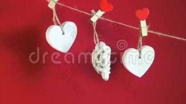 情人节`概念。 白色的木制心固定在红色背景的绳子上