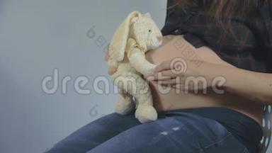 一位孕妇在玩长毛绒玩具摆姿势
