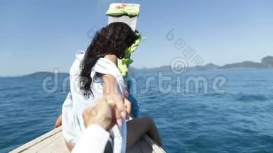 美丽的女人坐在泰国的船上牵着男人的手快乐的微笑