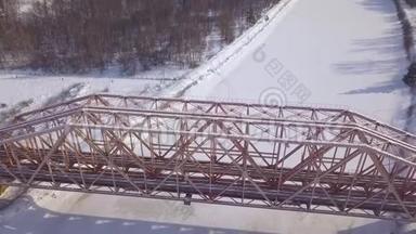 冬季景观冻江上列车运行的顶视悬索铁路桥梁。 空中观景火车桥