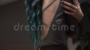 苗条的女孩在波西米亚的房间里拥抱自己。 涂了青绿色的头发.. 特写镜头。 美丽的背影