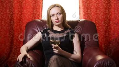 一个穿着黑色连衣裙，嘴唇上涂着红色<strong>口红的</strong>致命女人坐在一张皮椅上，手里拿着一杯白葡萄酒，