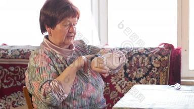 一位老年妇女在智能手表上检查信息。 她读提醒并说出搜索的短语。 之后