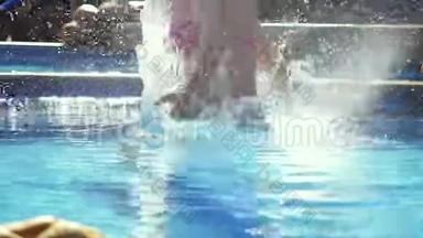 穿着粉红色比基尼的年轻苗条女子缓慢地跳入游泳池，在美丽的波克身上泼水