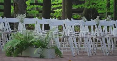 带花的白色结婚椅。 <strong>户外婚礼</strong>。 花园里的<strong>婚礼</strong>