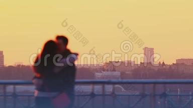 年轻夫妇在日落时接吻