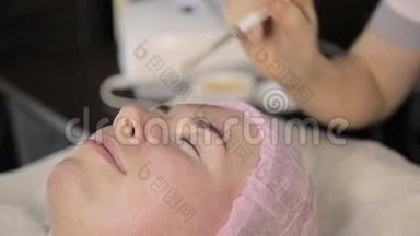 美容师为一个在美容院的女人做射频面部提升程序。 硬件美容