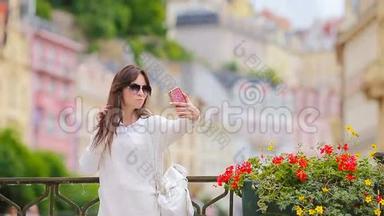 在欧洲城市拍摄自我肖像的年轻女子。 高加索游客在欧洲享受她的欧洲暑假