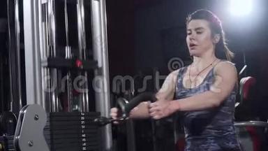<strong>健身房</strong>里的女孩。 体重训练。 在背部的肌肉上工作。 在<strong>健身房</strong>锻炼划船的女人。 妇女