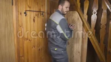 这位工人在木制的室内设置了一扇自制的门