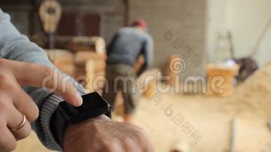 青年林业工程师在木头前触摸智能手表