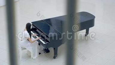 美丽的女钢琴家在歌剧厅弹钢琴。