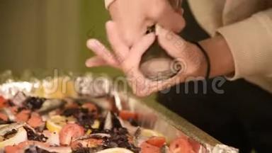 在家庭厨房里，一个女孩的手在<strong>手工</strong>磨<strong>坊</strong>的一个戳子里放着一个盘子或胡椒。 健康