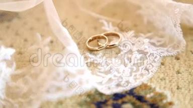 新娘的白色面纱上戴着两枚金色结婚戒指。 面纱上有两枚结婚戒指。 面纱上戴着结婚戒指。