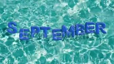 单词`9月`形状的充气游泳圈漂浮在<strong>清爽</strong>的蓝色游泳池里