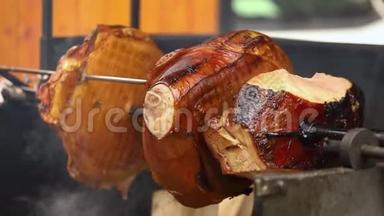 大块美味的猪肉火腿在明火上煮熟。 街头美食。 户外食品。 露营和烹饪