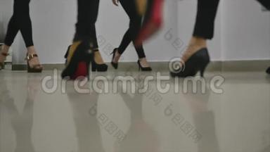 女腿在舞台上行走.. 把腿放在高跟鞋上走路。 冷静和自信的步骤