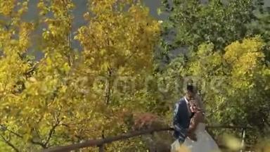 年轻漂亮的新婚夫妇一起在河边的公园里。 可爱的新郎和新娘。 <strong>结婚纪念</strong>日。 慢动作