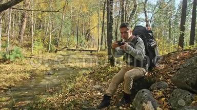 游客在森林中乘山河拍摄风景。 人拍摄如画的景色.. 他拍照和拍照
