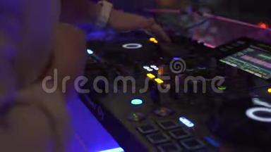 在夜总会的舞会上，DJ控制器和音乐控制台在五颜六色的<strong>灯光</strong>下。 DJ调音台和<strong>音响</strong>控制台