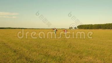 梦想飞翔。快乐童年理念。两个女孩在日落时玩玩具飞机。太阳背景下的孩子们