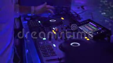 在夜总会的舞会上，DJ控制器和音乐控制台在五颜六色的<strong>灯光</strong>下。 DJ调音台和<strong>音响</strong>控制台