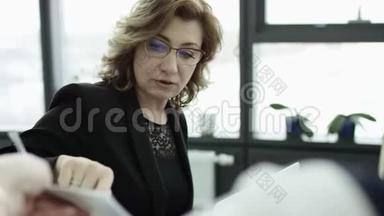 一位女经理在办公室会议上向同事介绍新的项目计划，女商人介绍