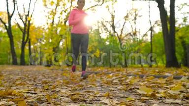 <strong>跑鞋</strong>-日落时在秋天公园系鞋带的女人。 。 慢动作