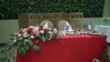眼镜，盘子，餐具和餐巾.. 为聚会装饰了鲜花的桌子。 婚宴，生日
