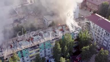 燃烧屋顶的一栋住宅高层建筑，云烟自火.. 消防队员灭火。 顶部