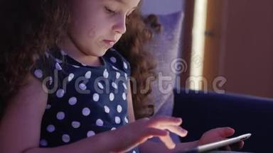 可爱的儿童娱乐与平板。 小女孩度过闲暇时光，玩手机游戏，在光明中破碎