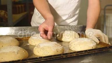 面包师为面包在面团上手工切开。 面包的制造。 面包店