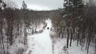 从空中观看<strong>越野车</strong>6x6，在冬季森林的积雪道路上行驶，后景