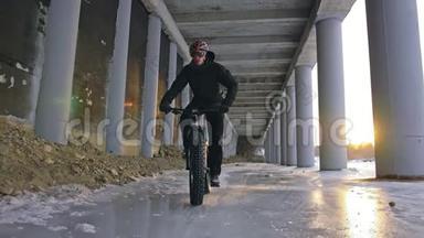 专业<strong>的</strong>极限运动员骑着一辆肥胖<strong>的</strong>自行车在户外。 骑自行车<strong>的</strong>人在冬天骑在雪冰上。 人类