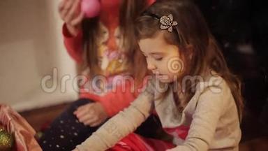 小女孩穿着舒适的<strong>家居服</strong>坐在地板上，穿着漂亮的圣诞装饰品。