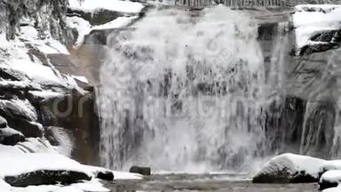 冬季瀑布。 小池塘和白雪皑皑的巨石，瀑布层层叠叠。 山河的水晶冻水和声音。