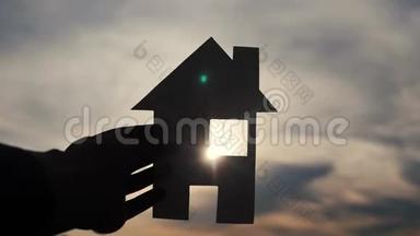 乐<strong>家居生活</strong>方式建设理念.. 一个人手里拿着一个纸房，手里拿着夕阳的剪影