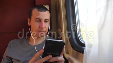 男子听着火车<strong>车厢车厢车厢车厢</strong>上的音乐旅行。 慢动作视频。 有智能手机的男人