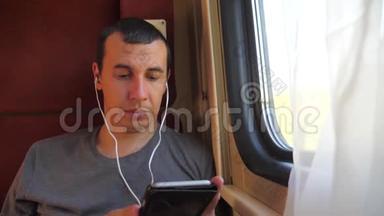 男子听着火车车厢车厢车厢车厢上的音乐旅行。 慢动作视频。 有生活方式的男人