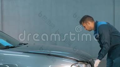 汽车车间的机械员检查油位。 卡车司机检查引擎。